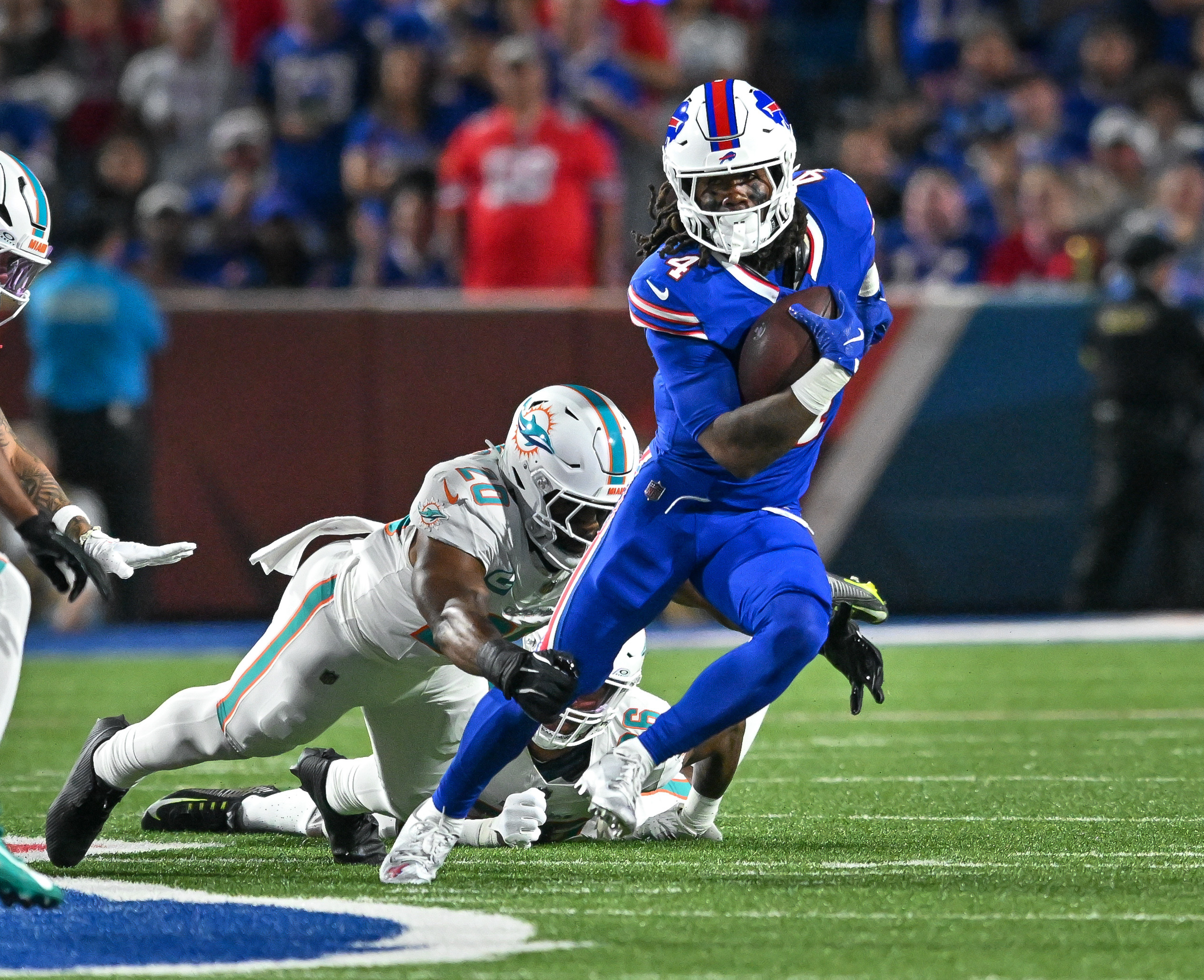 Buffalo Bills running back James Cook (4) tries to avoid Miami Dolphins linebacker Jordyn Brooks (20). Mark Konezny-Imagn Image