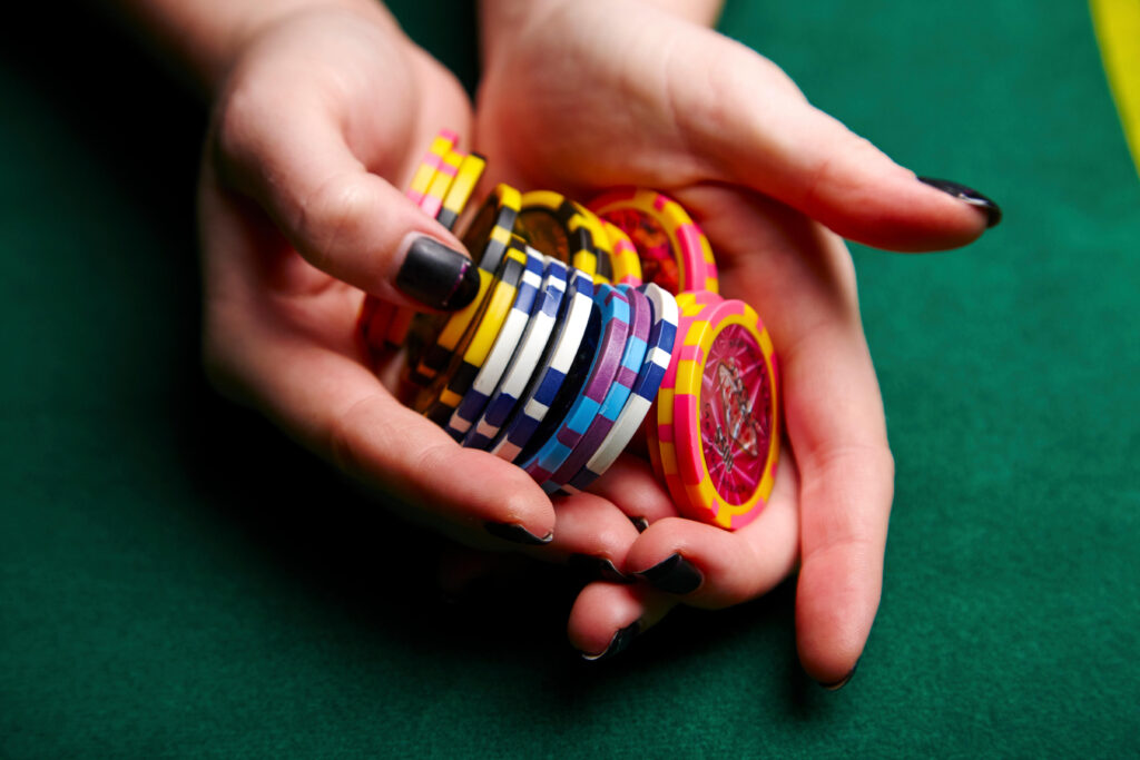 woman holding stack of casino chips